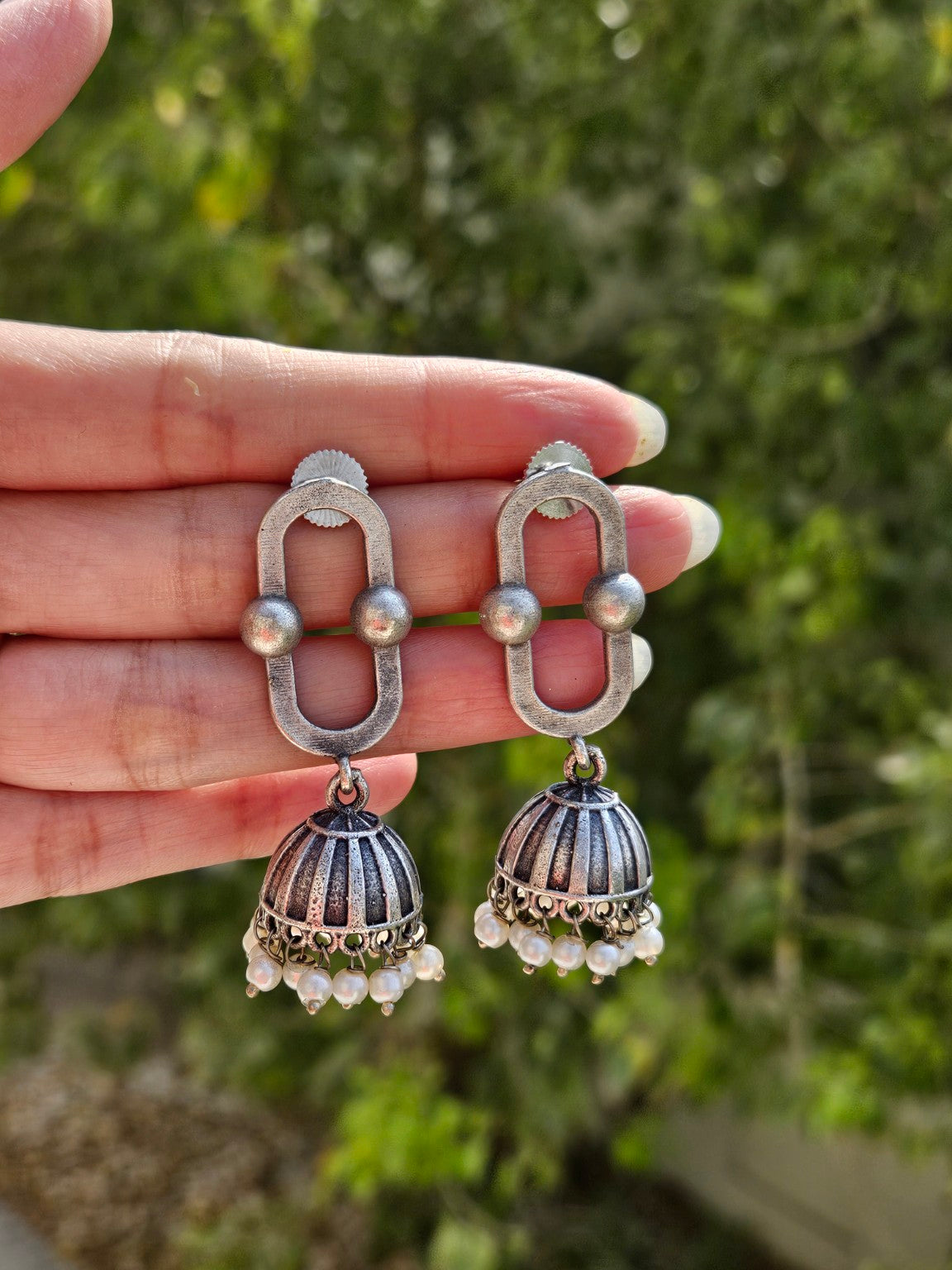 Oval link oxidized silver lookalike jhumka earrings in natural daylight