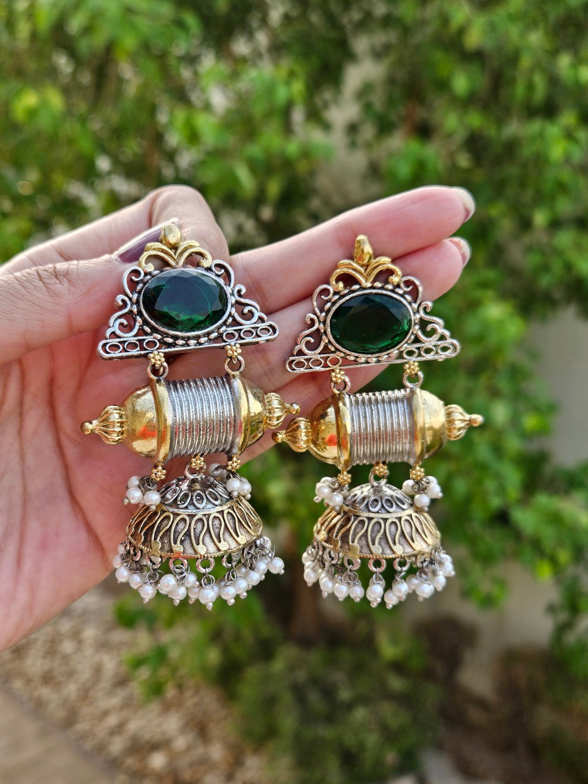 Green center dual tone statement jhumka earrings in natural daylight