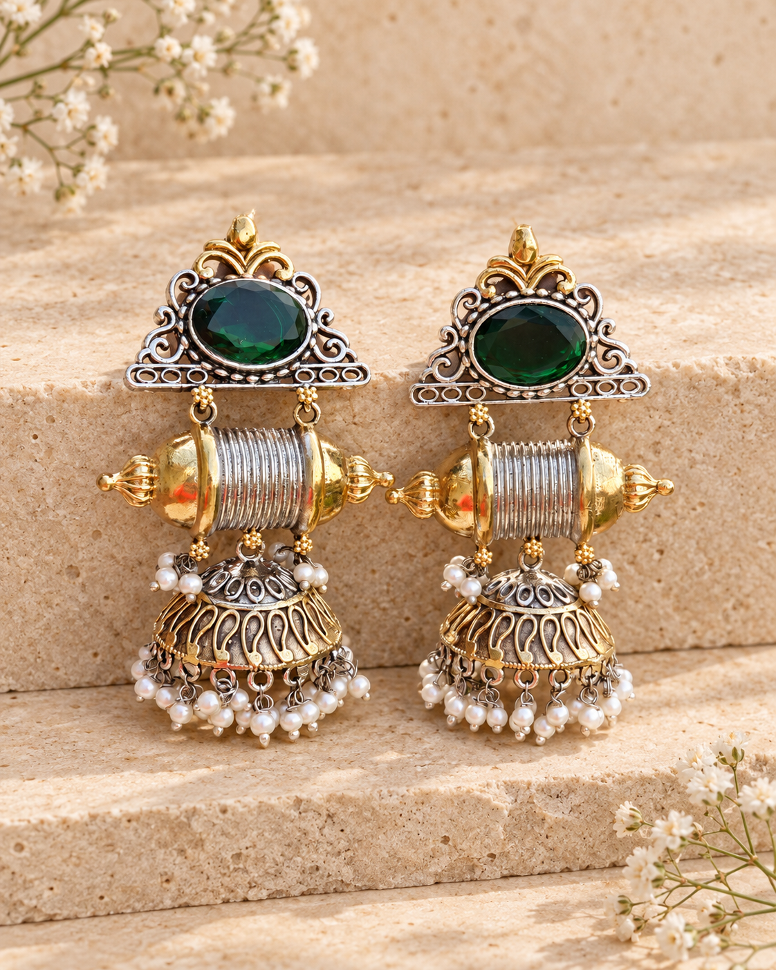 Green center dual tone statement jhumka earrings on beige stone background