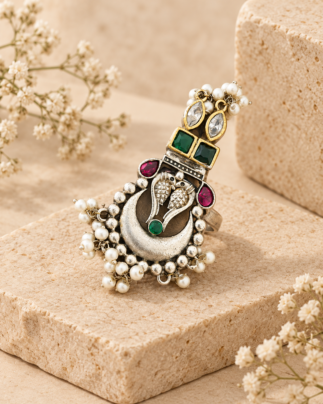 Dual tone peacock silver lookalike brass statement ring on beige stone background