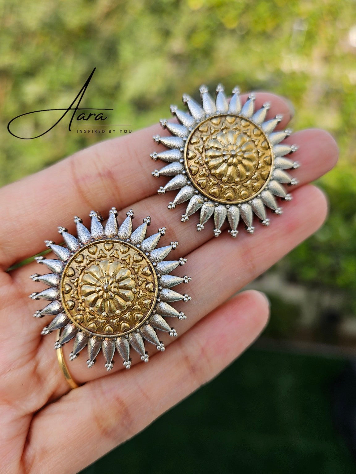 Dual tone gold and silver lookalike stud earrings in natural daylight