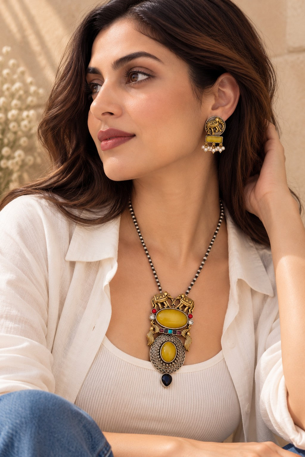 Model wearing yellow Aara dual tone elephant pendant set and matching earrings