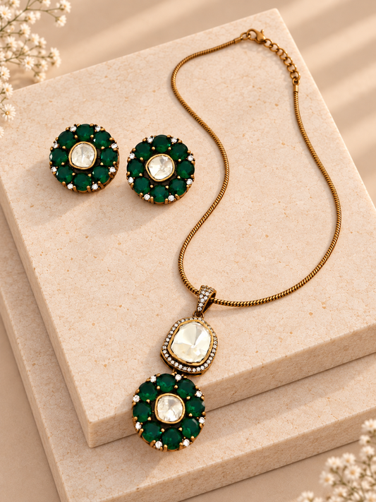 Green floral pendant necklace with its continuous gold-tone chain and matching stud earrings on two beige square stones.