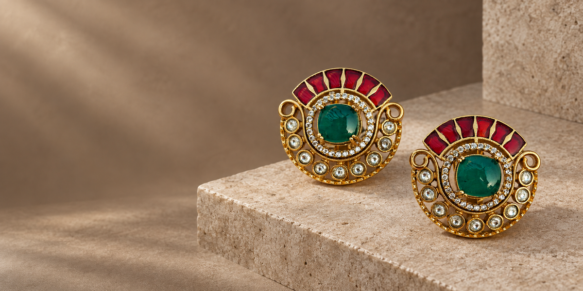 Green and ruby Jadau Kundan stud earrings on warm stone