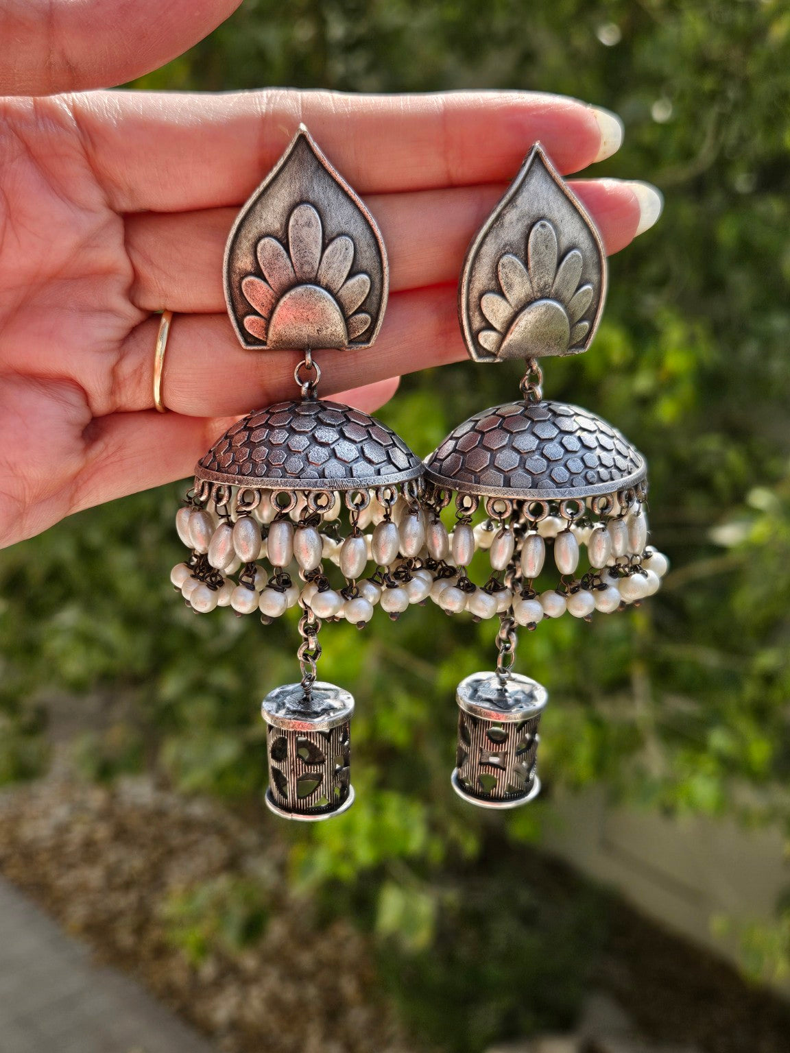 Leaf top oxidized silver lookalike jhumka earrings in natural daylight