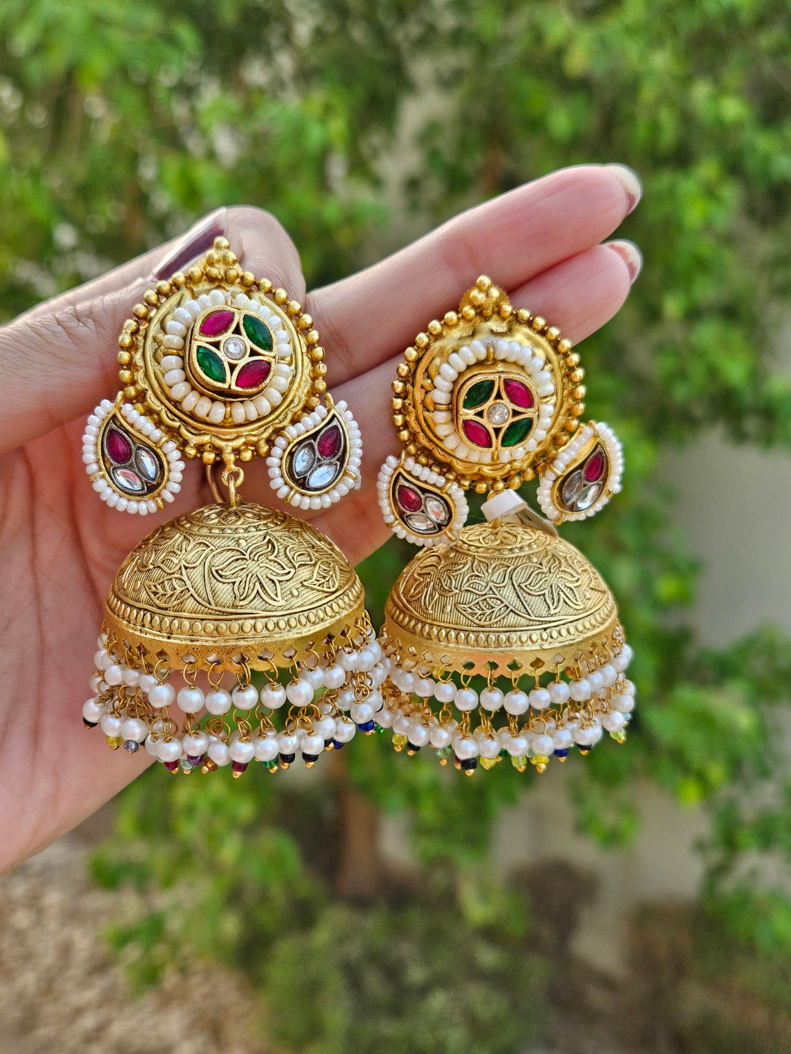 Natural daylight photo of lightweight gold plated Pachi Kundan jhumka with pearl hangings