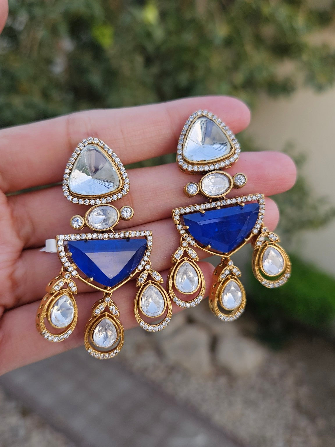 Blue doublet stone Moissanite Kundan Polki earrings photographed in natural daylight