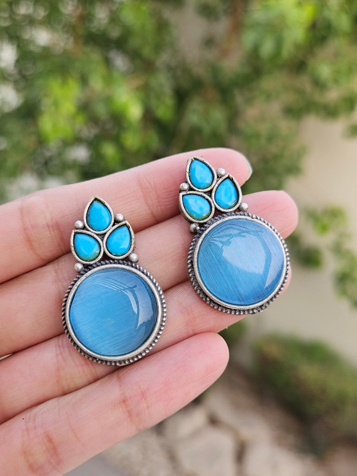 Blue Mona Lisa stone stud earrings in natural daylight