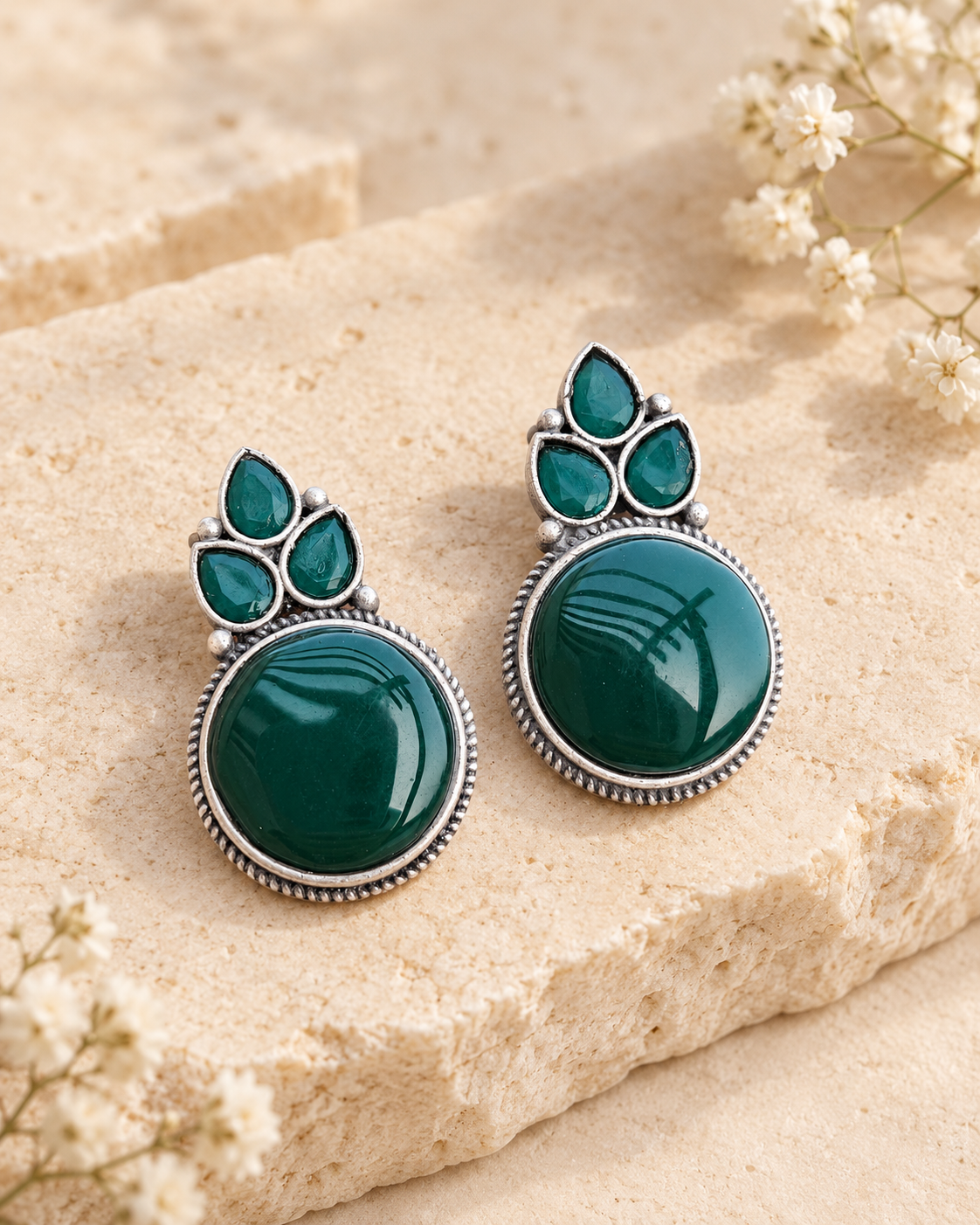 Green Mona Lisa stone stud earrings on beige stone background
