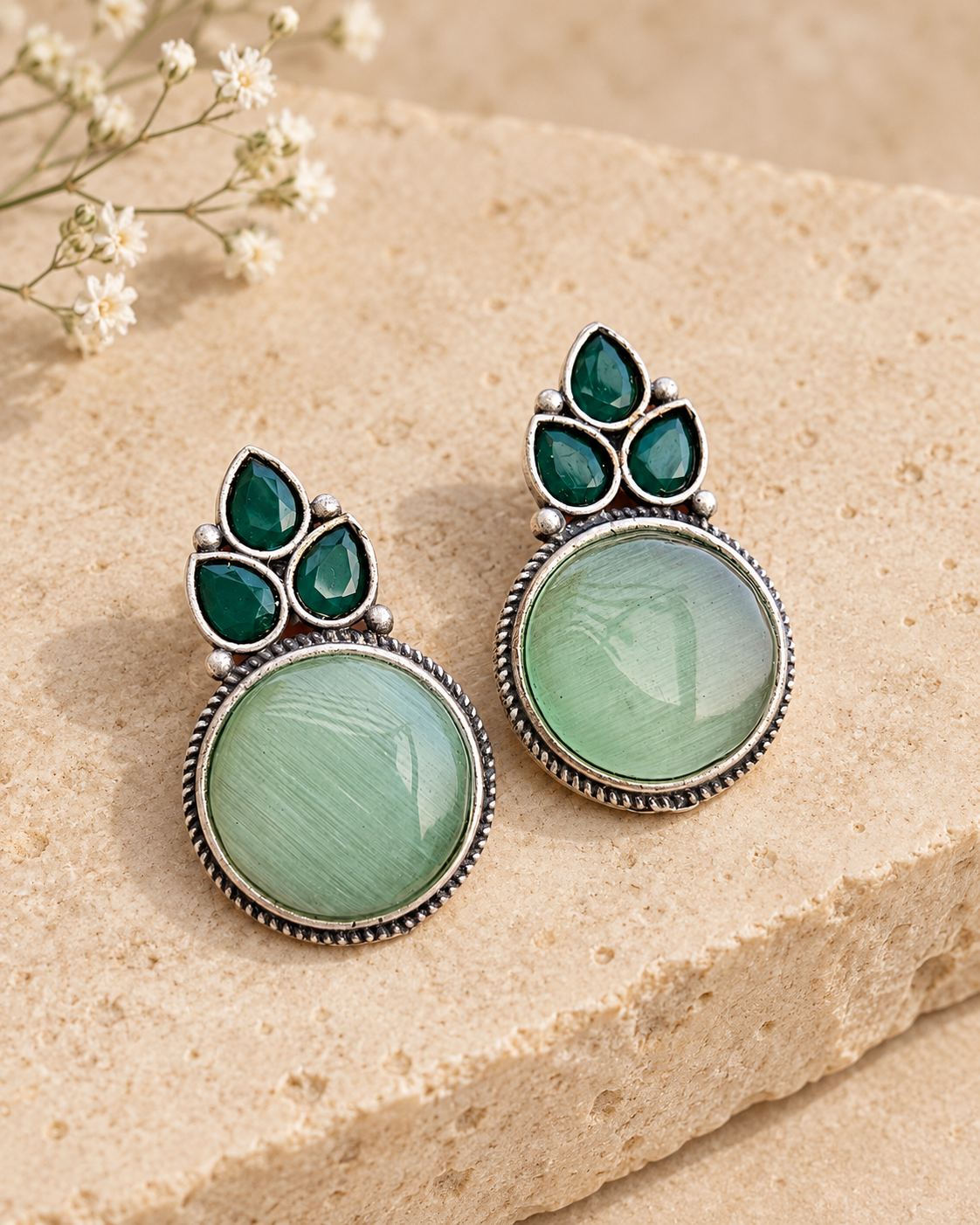 Mint Mona Lisa stone stud earrings on beige stone background