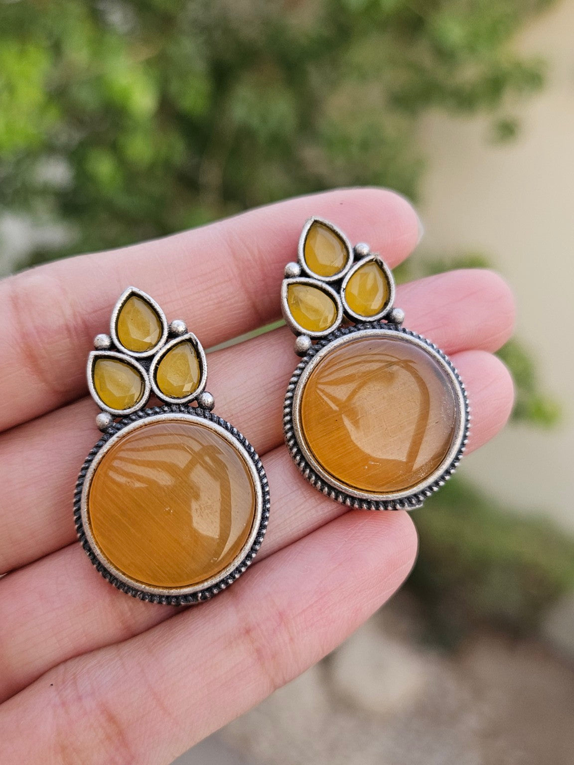 Yellow Mona Lisa stone stud earrings in natural daylight