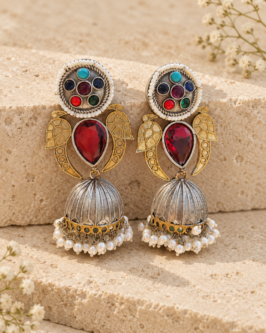 Multicolor dual tone statement jhumka earrings on beige stone background