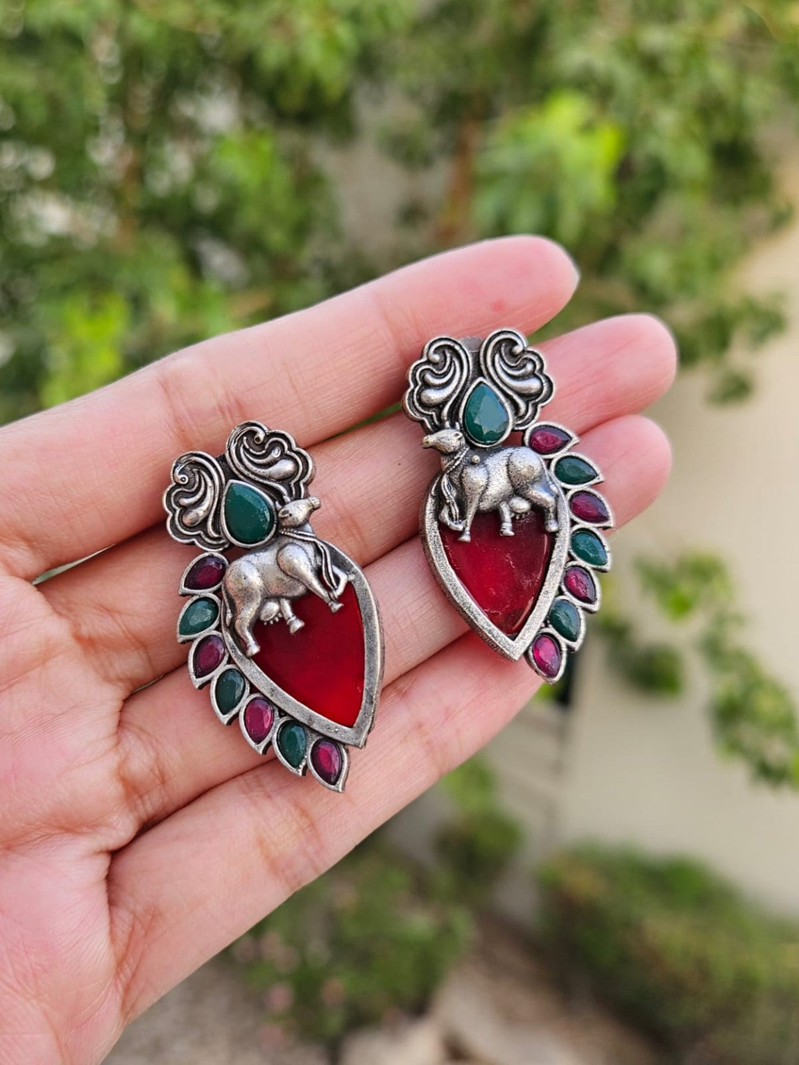 Red Nandi silver lookalike earrings with Mona Lisa stone in natural daylight