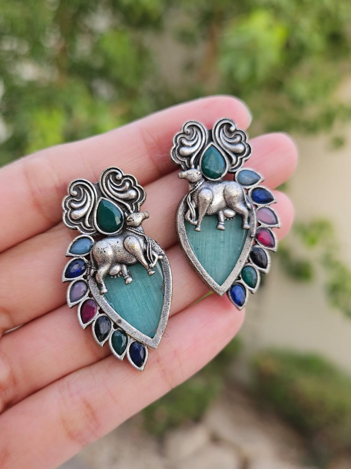 Teal Nandi silver lookalike earrings with Mona Lisa stone in natural daylight