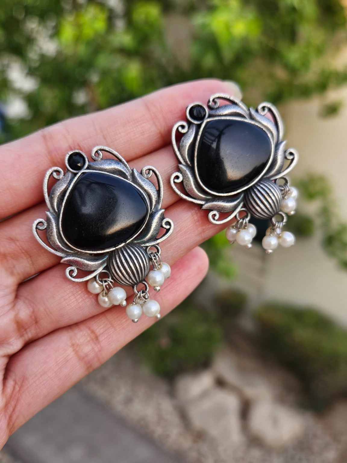 Black Mona Lisa stone silver lookalike earrings with pearl hangings in natural daylight