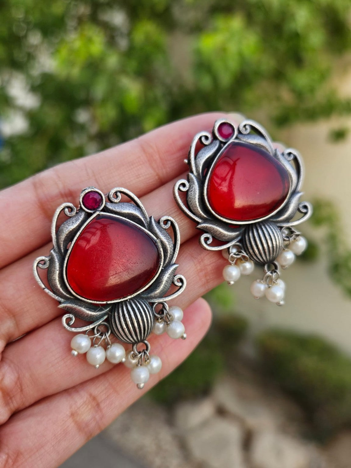 Red Mona Lisa stone silver lookalike earrings with pearl hangings in natural daylight