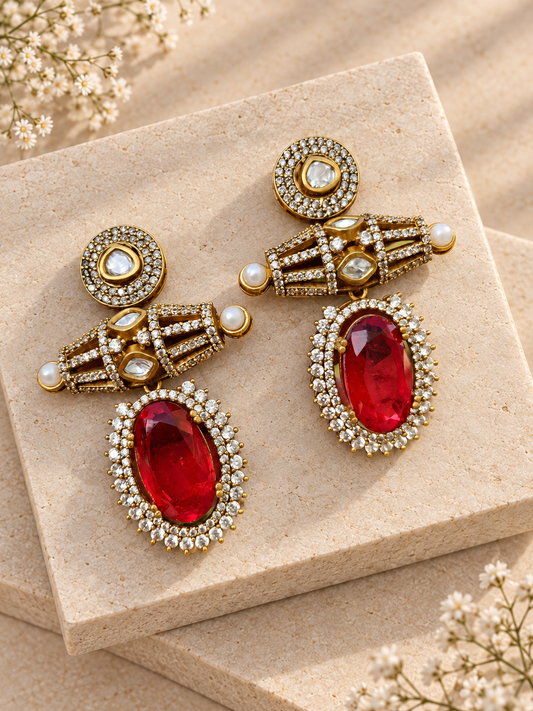 Red oval drop earrings with clear-stone studs, open gold-tone bars and small side pearls on beige square stones.