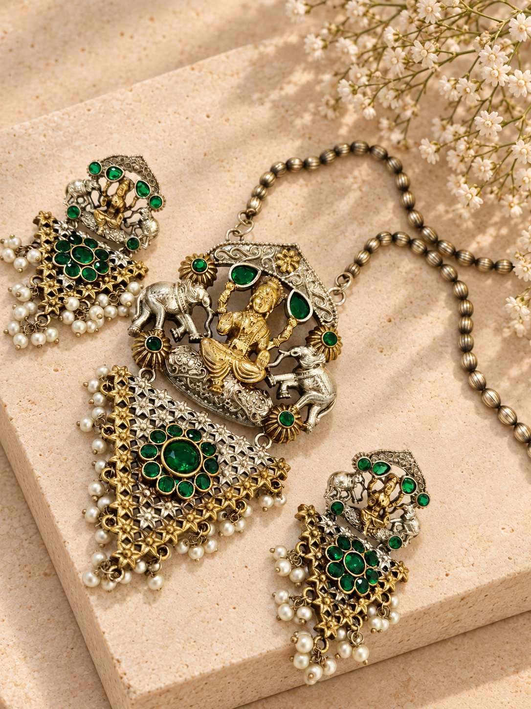 Silver Replica Dual Tone Monalisa Stone Lakshmi Pendant Set, Green colour, on beige square stone with small white flowers.