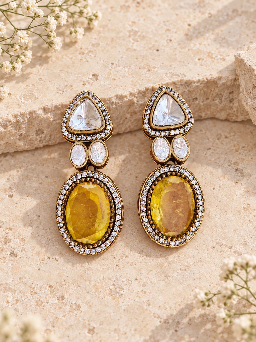 Yellow Moissanite Polki Kundan doublet stone earrings with AD detailing and antique gold finish on beige stone background