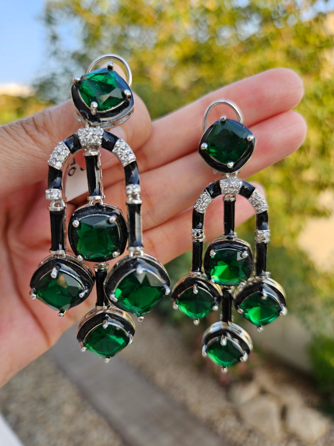 Green premium cut stone enamel earrings photographed in natural daylight